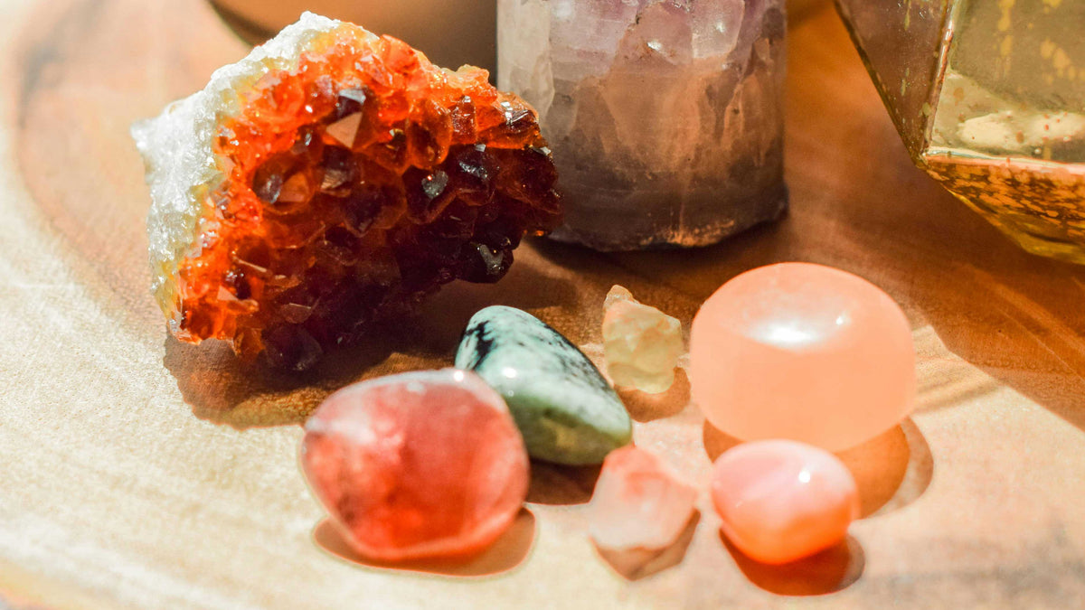 raw colored gemstones scattered across a wooden surface